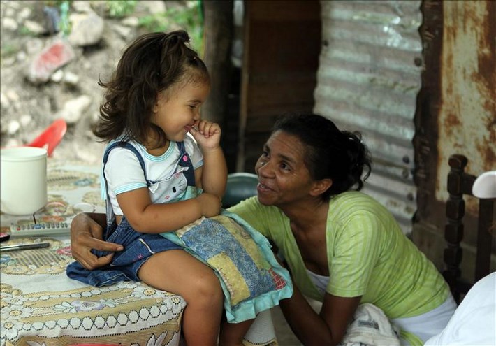 En la imagen, una niña y una mujer refugiadas colombianas hablando en un barrio de Ureña (Venezuela). EFE/Archivo