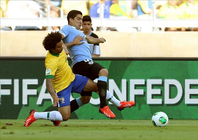 El defensa de la selección de Brasil, Marcelo Vieira (i), lucha el balón con Luis Suárez, delantero de Uruguay, durante la semifinal de la Copa de las Confederaciones en el estadio de Mineirao, en Belo Horizonte, Brasil. EFE