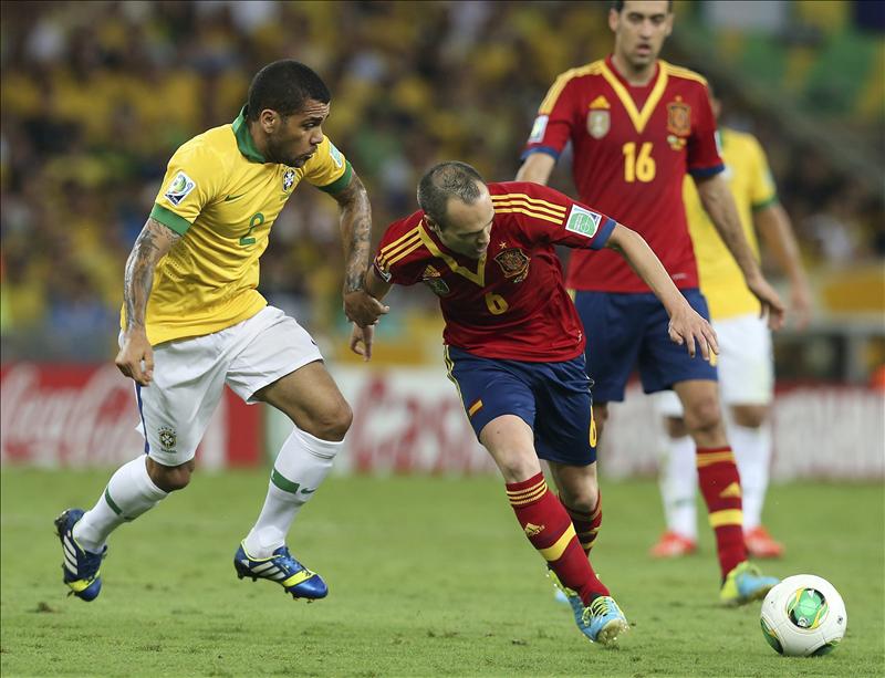 El defensa de la selección brasileña, Dani Alves (i) lucha por el balón con el centrocampista español Andrés Iniesta (d) durante la final de la Copa Confederaciones entre Brasil y España disputada en Maracaná, Río de Janeiro, Brasil hoy 30 de junio de 2013. EFE