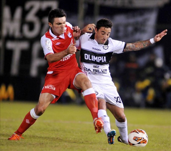 El jugador del Independiente Santa Fe de Colombia Daniel Torres (i) disputa el balón con Juan Manuel Salgueiro (d) del Olimpia de Paraguay en su partido de ida de la semifinal de la Copa Libertadores disputado en el estadio Defensores del Chaco. EFE