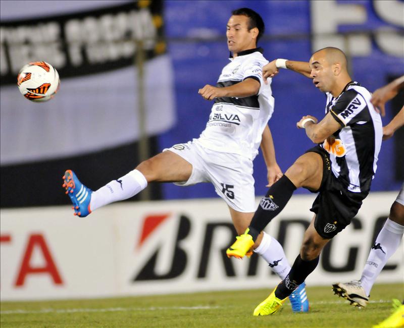 El jugador Herminio Miranda (i) de Olimpia de Paraguay disputa un balón con Diego Tardelli (d) del brasilero Atlético Mineiro, durante el partido de ida de la final de la Copa Libertadores en el estadio Defensores del Chaco de Asunción (Paraguay). EFE