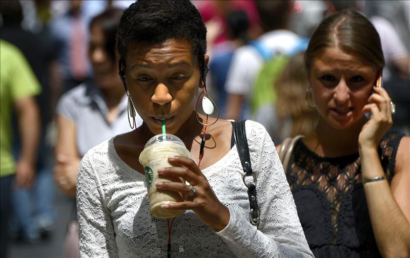 Una mujer bebe una bebida de tamaño gigante por las calles de Nueva York, Estados Unidos. EFE
