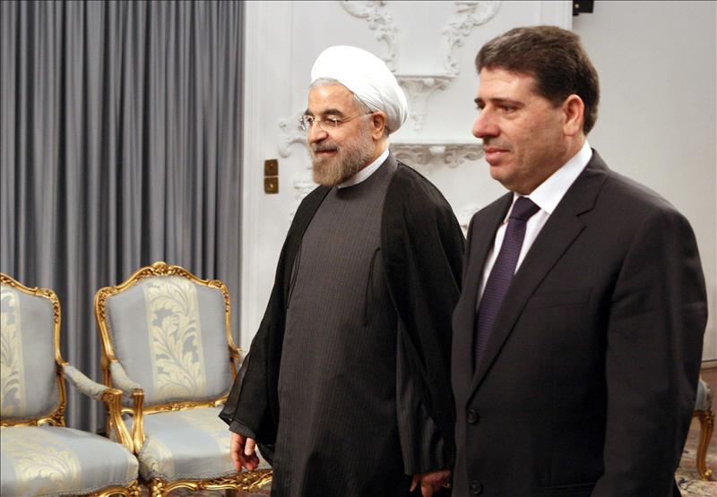 El nuevo presidente de Irán Hassan Rowhani (i) da la bienvenida al primer ministro sirio Wael Nader Al-Halqi (d) esta mañana en Teherán. EFE
