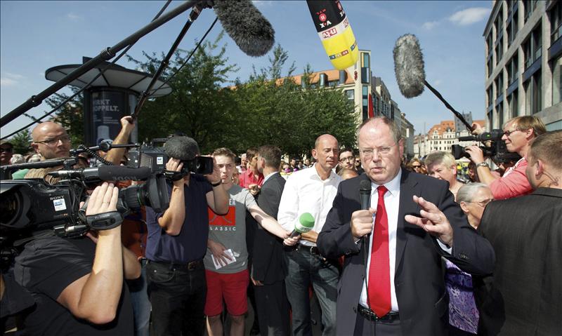 El candidato a canciller del Partido Socialdemócrata (SPD), Peer Steinbrueck (d), se dirige a su audiencia rodeado por los medios de comunicación en un puesto informativo del partido político en el centro de Leipzig, Alemania, el 22 de agosto de 2013.