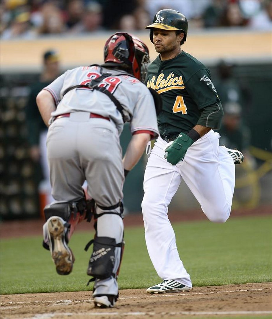 Los Piratas, Bravos y Dodgers no pudieron evitar la "barrida" El jugador de los Atléticos de Oakland Coco Crisp (d) anota ante el receptor Ryan Hanigan (i) de los Rojos de Cincinnati, durante un partido. EFE/Archivo