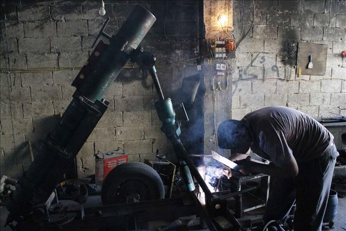 Un integrante de las tropas opositoras al régimen de Bachar al Asad, durante el proceso de fabricación de bombas y la reparación de artillería en el barrio de Tareq Al-Bab (Alepo). EFE