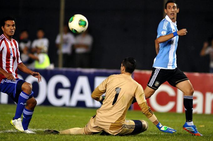 Salustiano Candia (i) y Roberto Fernandez (c) de Paraguay disputan el balón con Ángel Di María (d) de Argentina este 10 de septiembre de 2013. EFE