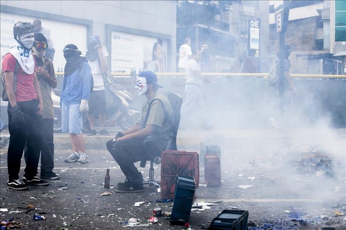 Jóvenes opositores al Gobierno de Nicolás Maduro bloquean una calle en Caracas.