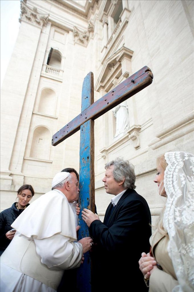 El papa Francisco besa una cruz hecha con dos tablones de una patera de inmigrantes que llegó a la isla de Lampedusa