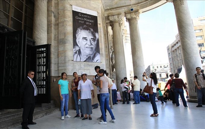 Personas en el Palacio de Bellas Artes donde resaltan imágenes del escritor colombiano Gabriel García Márquez. EFE
