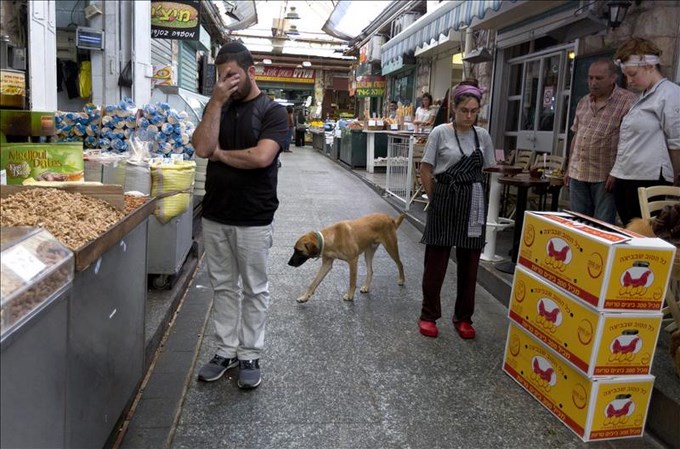 Varias personas guardan un minuto de silencio a las puertas de una cafetería en Jerusalén. EFE