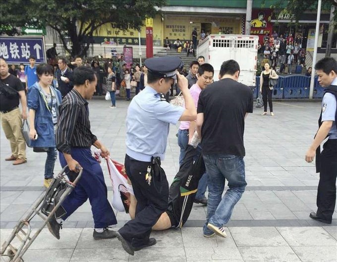 Hombres arrastran a sospechoso tras ataque con un cuchillo en China, hoy. EFE