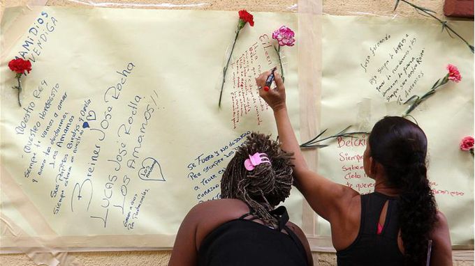 Familiares y amigos de las víctimas del bus en el que fallecieron 32 niños colombianos, escriben mensajes en un mural. EFE