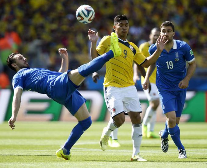 El centrocampista griego Konstantinos Katsouranis (i) despeja el balón ante su compañero, el defensa Sokratis Papastathopoulos (d) y el delantero colombiano Teófilo Gutiérrez (c), durante el partido. EFE