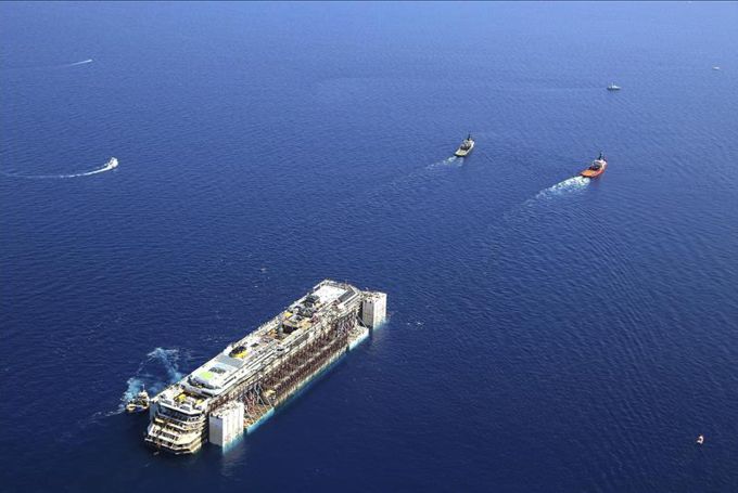 Fotografía aérea cedida por el gabinete de prensa de la compañía Costa que muestra al crucero Costa Concordia siendo remolcado desde la isla del Giglio . EFE