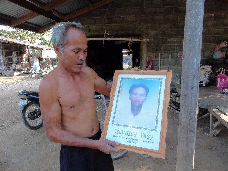 Arun Jaikaew sostiene el retrato de su hijo fallecido y reencarnado como el hijo de un vecino.