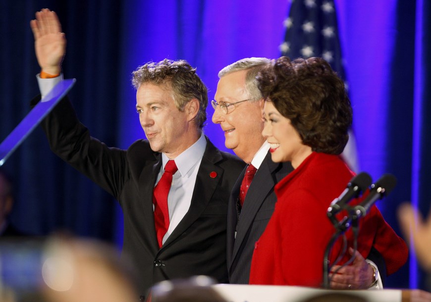 El senador republicano de Kentucky Mitch McConnell (c), saluda a sus seguidores junto a su esposa, Elaine Chao (d) y el senador Rand Paul (i),