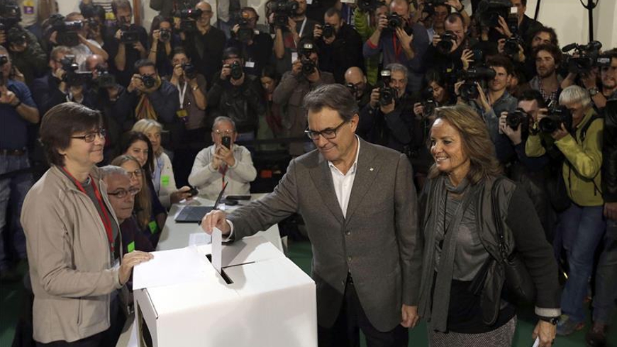 El presidente de la Generalitat, Artur Mas, acompañado de su esposa,Helena Rakosnik, en la Scola Pia de Balmes donde depositó su papeleta en la jornada participativa. EFE