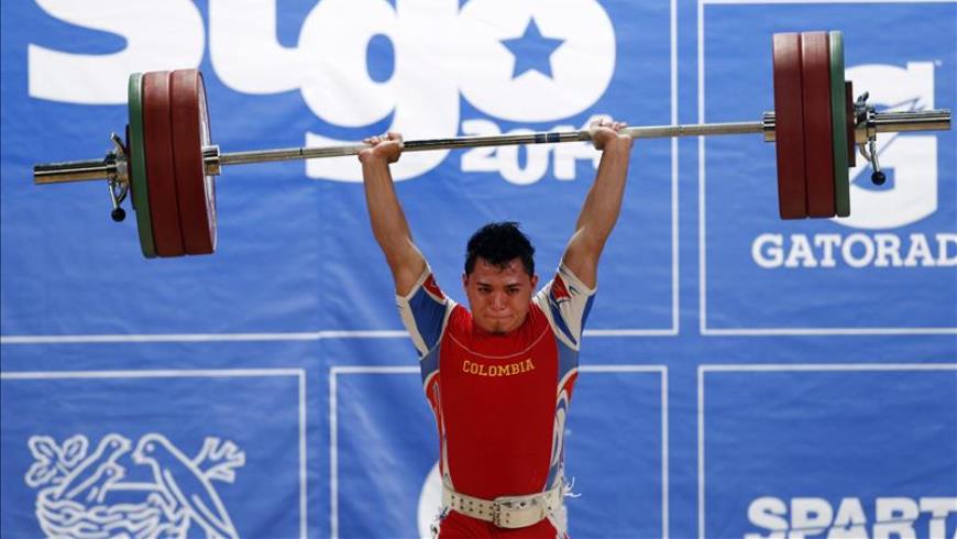 Carlos Berna de Colombia, medalla de oro, compite en la categoría masculina 56kg. de levantamiento de pesas. EFE