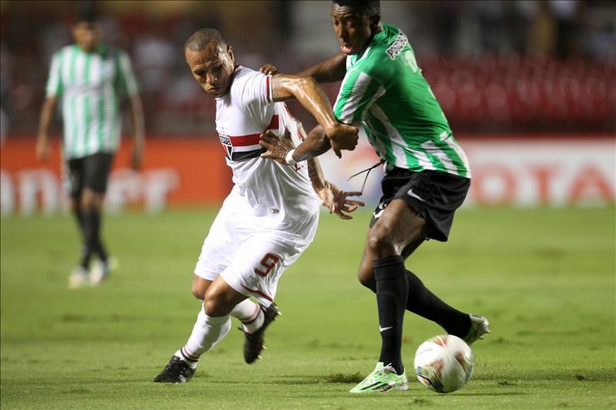 Luis Fabiano (i) disputa el balón con Oscar Murillo (d) de Nacional. EFE
