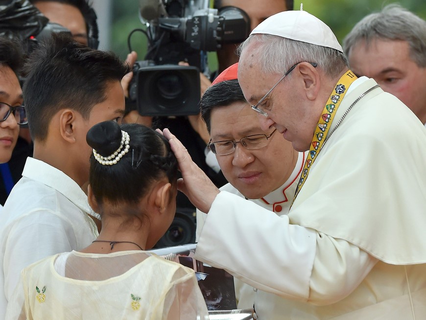 El Papa francisco habla con dos jóvenes, hoy en la Universidad Santo Tomás de Manila. EFE