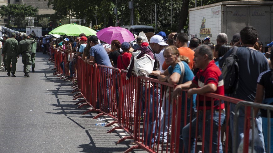 Un grupo de personas hace fila para ingresar a un punto al aire libre de venta de comida regulada por el Gobierno venezolano, el 24 de enero de 2015, en Caracas (Venezuela). EFE