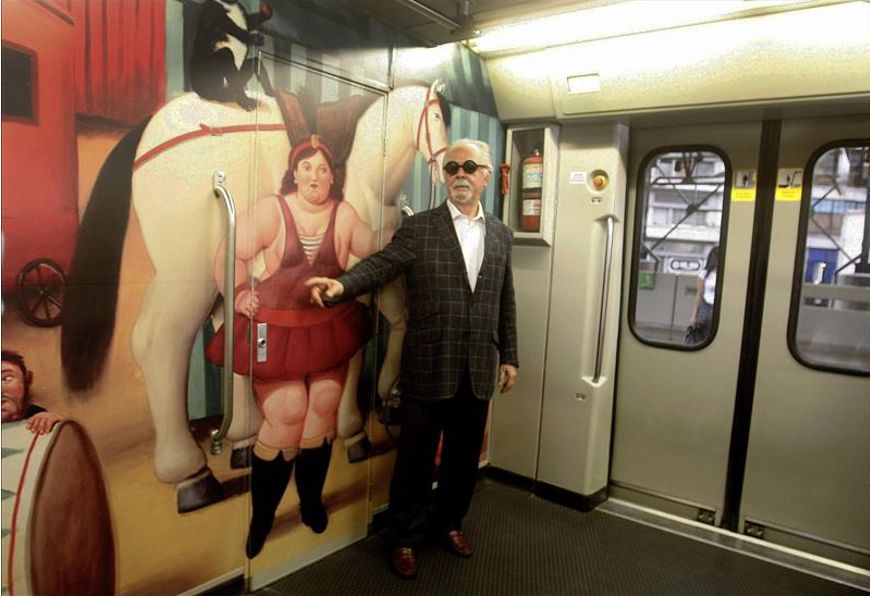 El maestro colombiano Fernando Botero fue registrado este viernes en un vagón del metro en Medellín (Colombia), junto a una réplica de una de sus pinturas de la exposición 'El Circo'. EFE