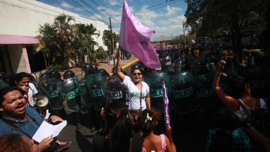 Varios hombres y mujeres se manifiestan frente a un grupo de policías antimotines durante una marcha en Managua (Nicaragua) durante la conmemoración del Día Internacional de la Mujer. EFE