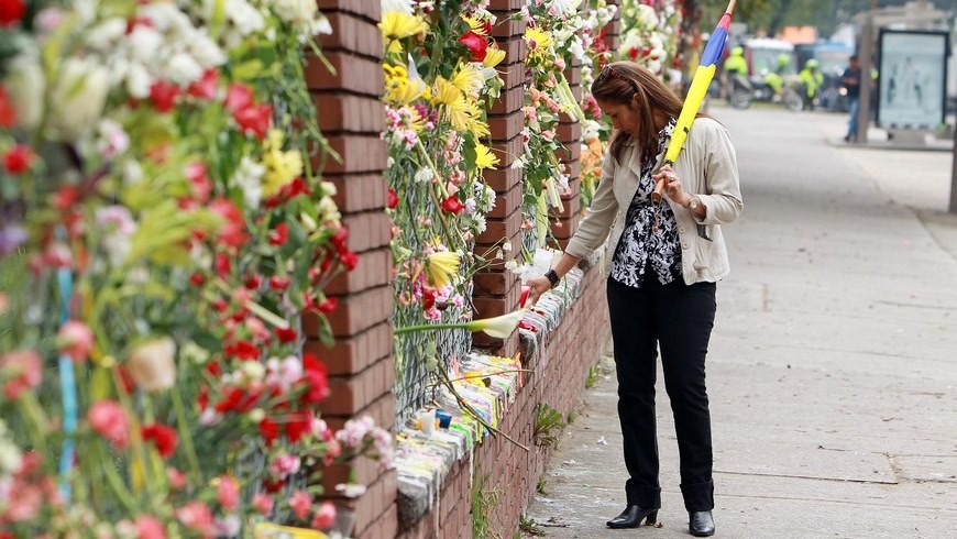Esta mujer deja flores en la reja Norte del Cantón Militar del Ejército