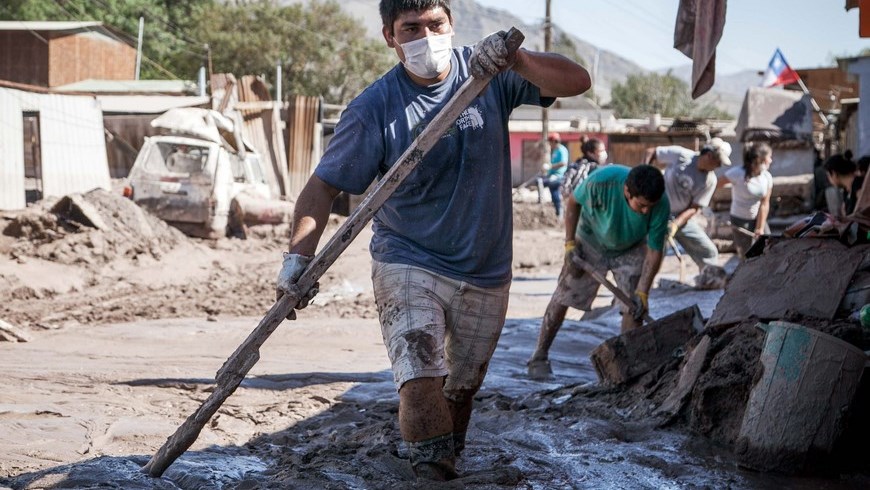 Habitantes participan en la limpieza de una calle anegada de lodo, el pasado viernes 3 de abril de 2015, en la localidad de Paipote (Chile). EFE