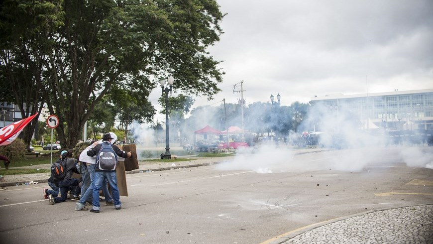 Fotografía cedida por la Alcaldía de Curitiba muestra a manifestantes que se refugian mientras la policía lanza gases lacrimógenos hoy, miércoles 29 de abril de 2015, durante una protesta de profesores en Curitiba (Brasil). EFE