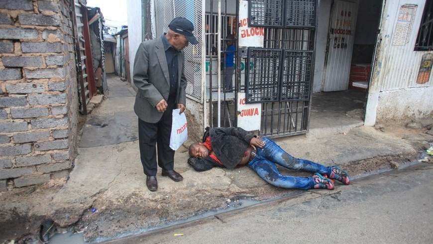 Un hombre permance tendido en la calle después de haber sido presuntamente apuñalado por una multitud en el municipio de Alexandra, en Sudáfrica. EFE