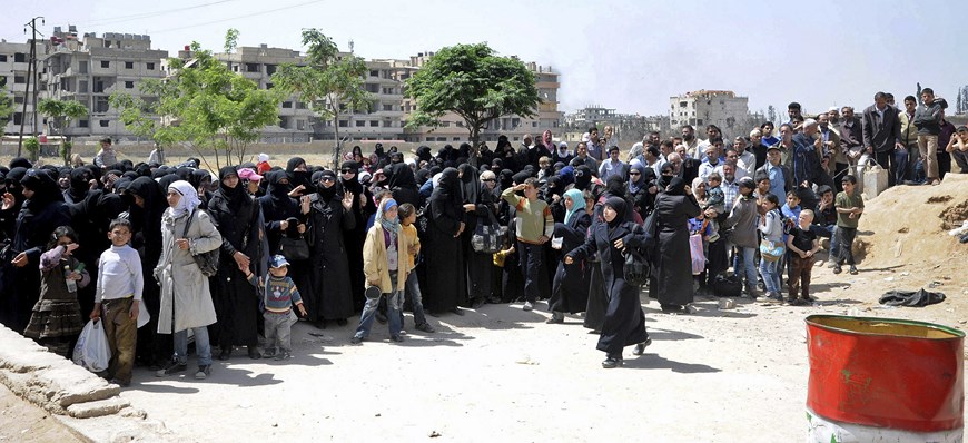 DAM02 DAMASCO (SIRIA), 28/04/2015.- Fotografía facilitada por la agencia de noticias oficial siria (SANA) que muestra a un grupo de sirios esperando para recibir ayuda humanitaria de parte de Cruz Roja y Media Luna Roja Siria, en Damasco, Siria, hoy, martes 28 de abril de 2015. Siria ha entrado en el cuarto año de una guerra civil que ha causado el desplazamiento de millones de personas y la muerte de al menos 220.000. EFE/-/SÓLO USO EDITORIAL/PROHIBIDA SU VENTA