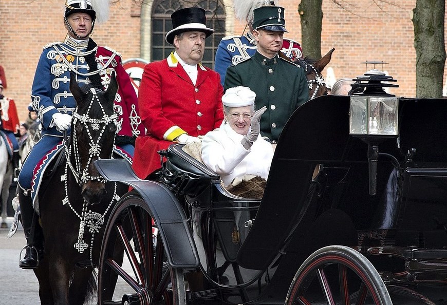 La reina Margarita de Dinamarca y su marido, el príncipe Enrique, saludan desde una carroza durante su visita a la ciudad Aarhus.
