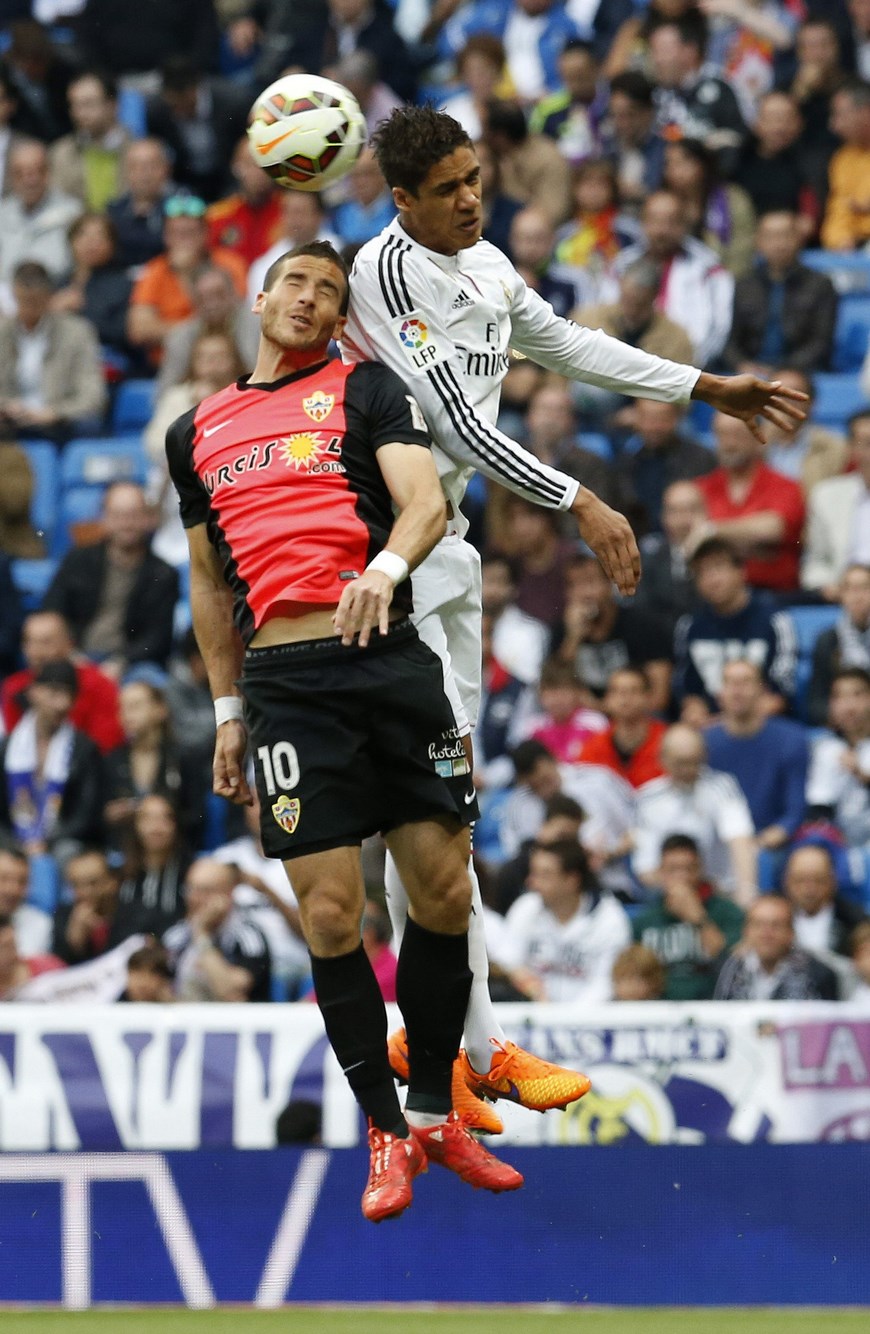 El defensa francés del Real Madrid, Raphael Varane (d), disputa el balón con el delantero israelí del Almería, Tomer Hemed, en el partido de la trigésima cuarta jornada de Liga en Primera División, que se juega en el estadio Santiago Bernabéu. EFE/Alberto Martín