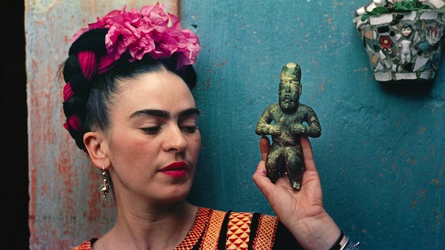Fotografía cedida hoy, martes 12 de mayo de 2015, de la artista Frida Kahlo sosteniendo una figura. EFE/Jardín Botánico de Nueva York