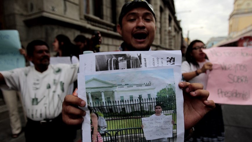Un manifestante enseña la foto de un amigo suyo que apoya la protesta contra la corrupción desde Washington mientras un grupo de personas pide que la terna propuesta para vicepresidente propuesta por el mandatario guatemalteco, Otto Pérez Molina, sea cambiada, frente al Congreso de Guatemala en Ciudad de Guatemala. EFE
