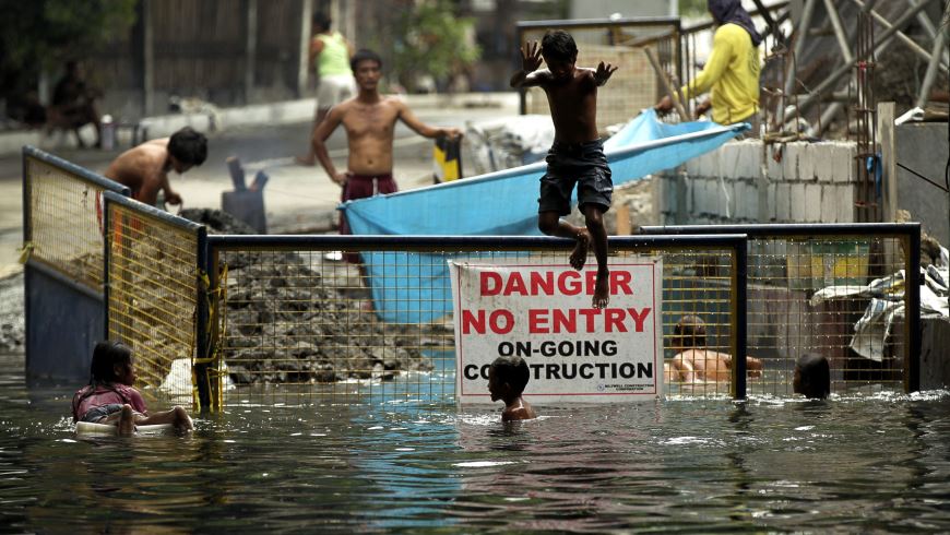 Niños filipinos se bañan en una zona inundada junto a unas obras tras una tormenta en Manila (Filipinas), ocasionada por el tifón Noul que afectará a Filipinas y Taiwán. EFE.