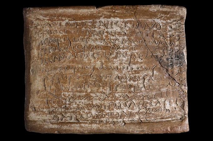 Fotografía facilitada por la Superintendencia de Bienes Culturales de Roma, de una Carta de Maximus (teja escrita), en la que un amo se lamenta de que una esclava embarazada haya perdido a su hijo, también de su propiedad, que forma parte de la exposición "Espartaco. Esclavos y amos en Roma". EFE