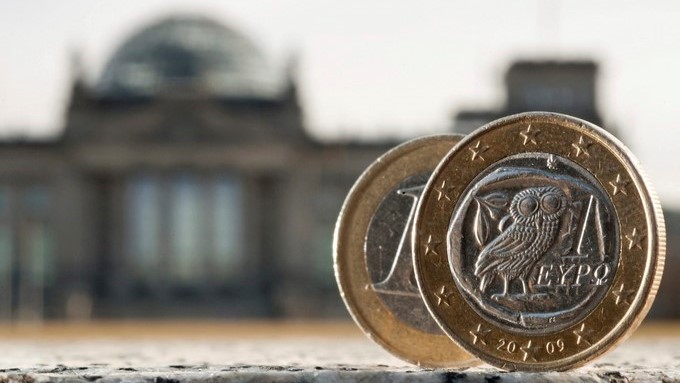 Dos monedas de euro, una de ellas acuñada en Grecia, fotografiadas delante del Bundestag en Berlín (Alemania). EFE/Archivo
