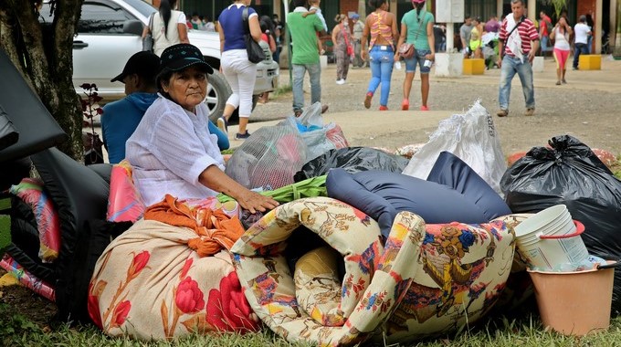 Una mujer permanece junto a sus pertenencias a las afueras de un refugio tras la avalancha que el pasado 1 de abril afectó 17 barrios en Mocoa (Colombia). EFE