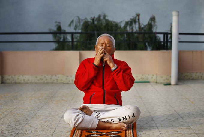 El alpinista nepalés Min Bahadur Sherchan, de 85 años, realiza unos ejercicios respiratorios en la terraza de su casa en Katmandú (Nepal) hoy, 5 de abril de 2017. EFE