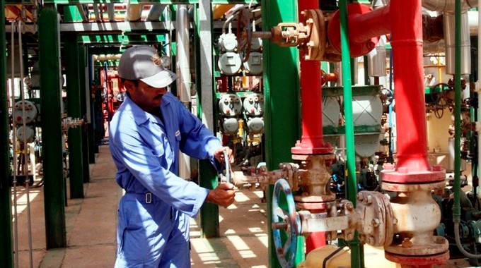 Un operario ajusta una válvula en la refinería de Irak. EFE/Archivo
