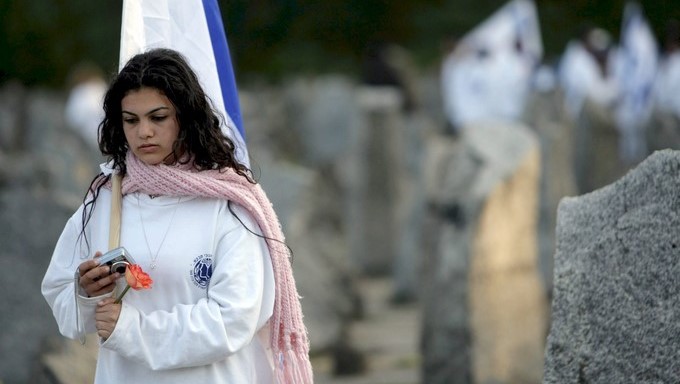 Una joven sostiene una bandera de Israel durante una ceremonia en el museo de la Lucha y el Martirio, ubicado en el antiguo campo de concentración de Treblinka, Polonia. EFEArchivo