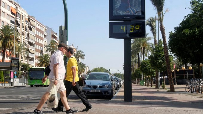 Dos personas pasan junto a un termómetro en Córdoba que ha alcanzado los 43º. EFE/Archivo