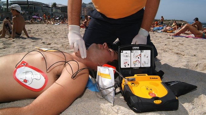 Un miembro de Protección Civil practica un simulacro del uso de un desfibrilador semiautomático externo (DESA) para los paros cardiacos en la playa de Riazor en A Coruña (España). EFE/Archivo