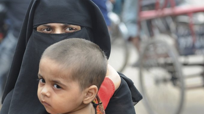 Una mujer musulmana sujeta a su hijo mientras camina por las calles de la ciudad de Nueva Delhi (India). EFE