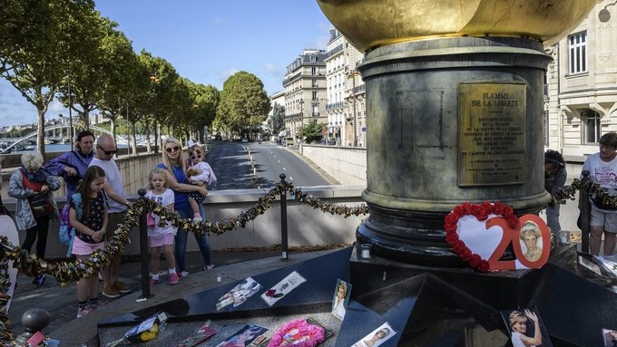 Varias personas dejan flores y fotografías en el monumento de la Llama de la Libertad sobre el puente del Almá en honor a la difunta princesa británica Diana de Gales, en París (Francia), hoy 31 de agosto de 2017. EFE
