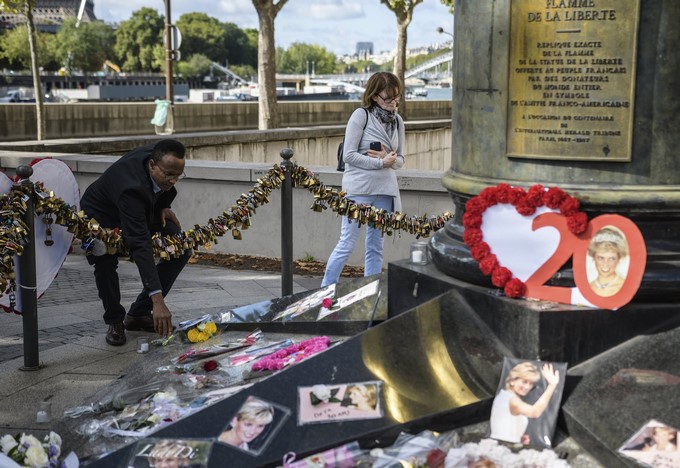 Varias personas dejan flores y fotografías en el monumento de la Llama de la Libertad sobre el puente del Almá en honor a la difunta princesa británica Diana de Gales, en París (Francia), hoy 31 de agosto de 2017. EFE
