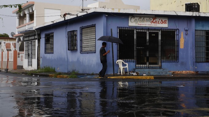 Un hombre se protege de la lluvia en una calle solitaria hoy, miércoles 6 de septiembre de 2017, ante el inminente paso por la isla del huracán Irma, de categoría 5, en San Juan (Puerto Rico). EFE